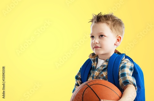 Smiling boy holding a basketball ball and posing © BillionPhotos.com