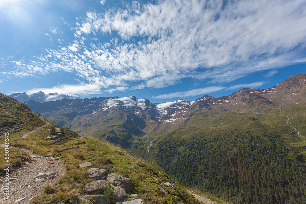 Panorama on the glaciers of the Palla Bianca massif seen from a path with a panoramic bench, Alto Adige - Sudtirol, Italy. Popular mountain for climbers and travel destination