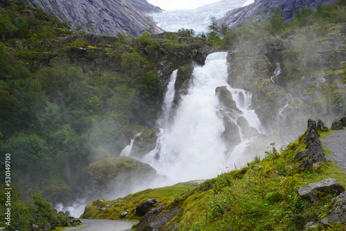 Blick auf den Kleivafossen Wasserfall mit hoher Gicht und dem Briksdalsbreen Gletscher in Norwegen