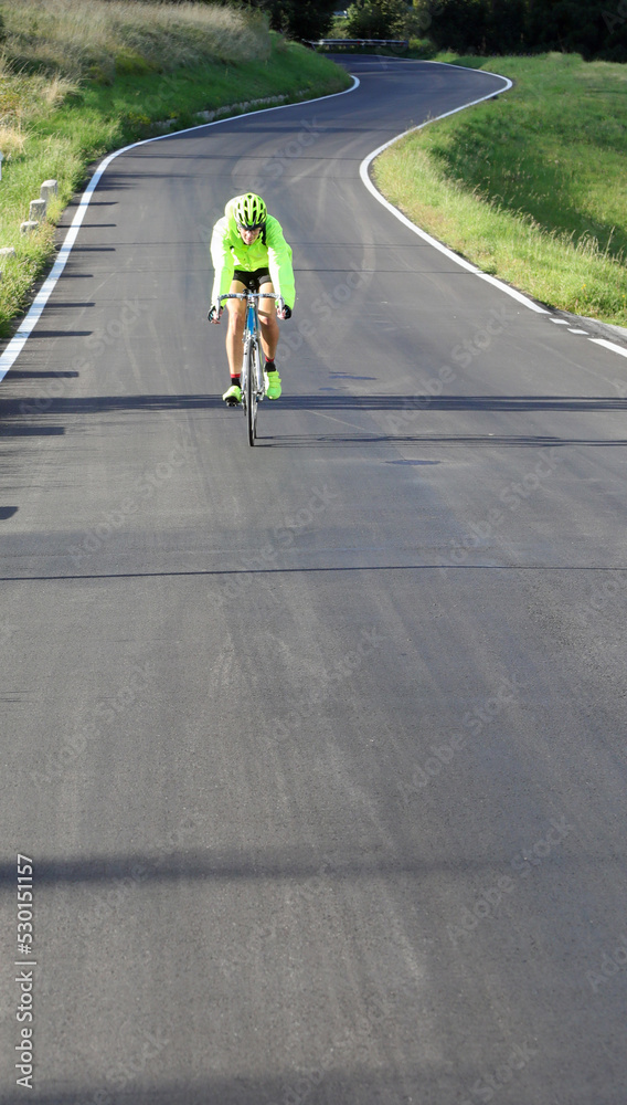 Fototapeta premium young cyclist with racing bicycle and phosphorescent waterproof jacket