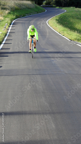 young cyclist with racing bicycle and phosphorescent waterproof jacket