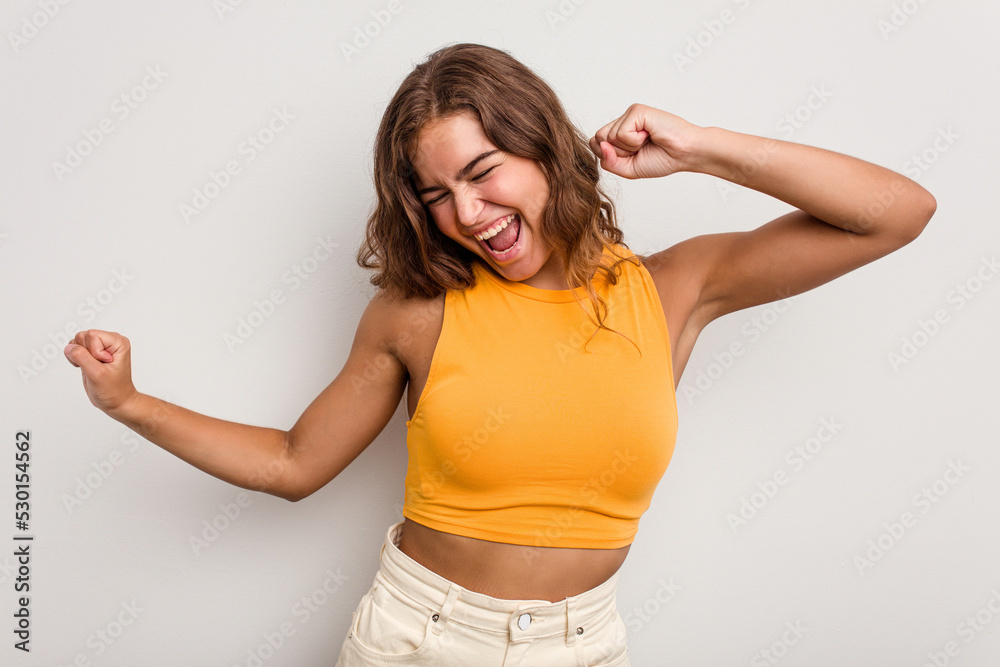 Young caucasian woman isolated on blue background dancing and having fun.