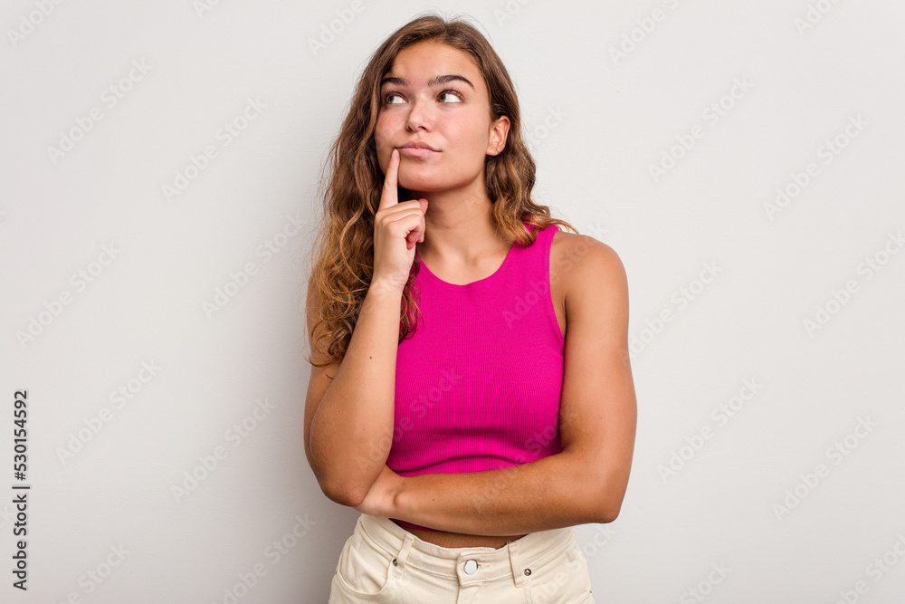 Young caucasian woman isolated on blue background contemplating, planning a strategy, thinking about the way of a business. Young caucasian woman isolated on blue background contemplating, planning a strategy, thinking about the way of a business.