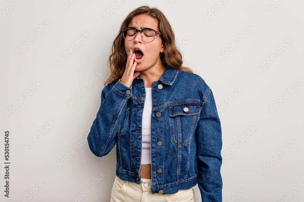 Young caucasian woman isolated on blue background yawning showing a tired gesture covering mouth with hand. Young caucasian woman isolated on blue background yawning showing a tired gesture covering mouth with hand.