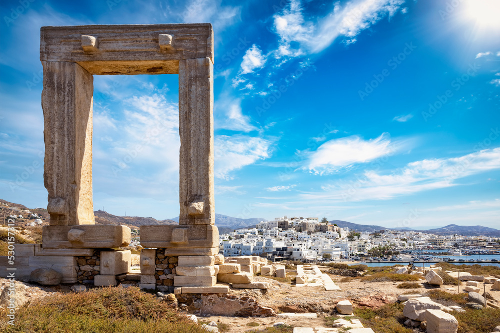 The famous gate of Naxos island, so called Portara from the temple of Apollon, in front of the whitewashed houses of the city,  witout people, Cyclades, Greece