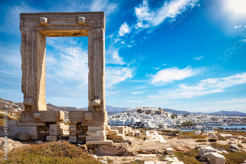 The famous gate of Naxos island, so called Portara from the temple of Apollon, in front of the whitewashed houses of the city, witout people, Cyclades, Greece