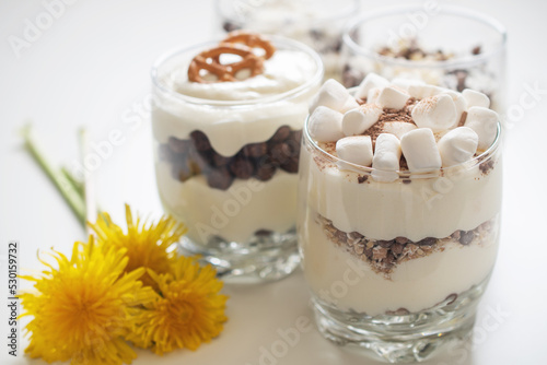 Delicious sweet dessert with cream in a glass on a light background, a beautiful breakfast