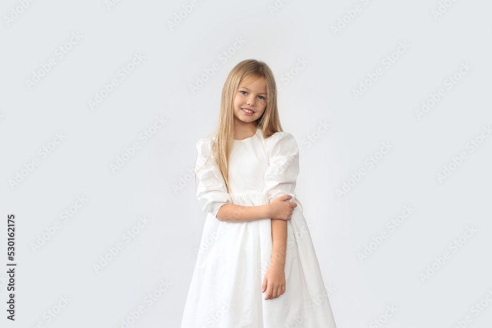Beautiful blond girl in a white dress is standing on a white background Beautiful blond girl in a white dress is standing on a white background
