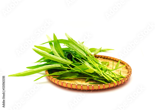 Bamboo flat winnowing basket with bunch of fresh cut water spinach or kangkung plant with tender shoots isolated on white background photo