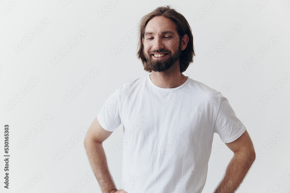 Portrait of a man with a black thick beard and long hair in a white T-shirt on a white isolated background Portrait of a man with a black thick beard and long hair in a white T-shirt on a white isolated background