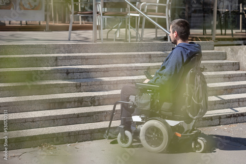 Photography Person with disability on electric wheelchair stopping at the bottom of inaccess