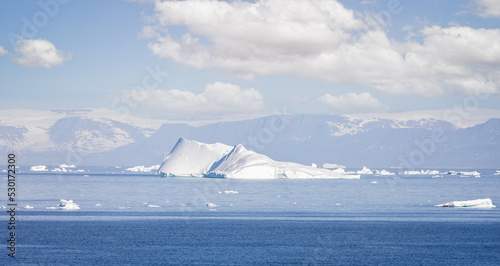 Icebergs big and small in the icefjord at Ilulissat  Greenland with majestic snow capped mountains in the background