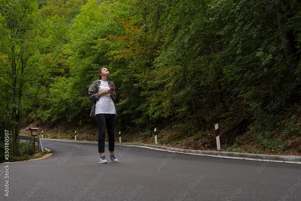 the girl is talking on the phone on the road the girl is talking on the phone on the road