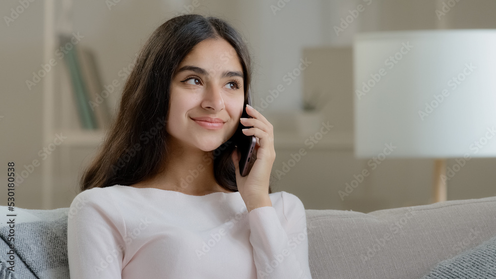 Arabian girl happy client talking mobile phone at home friendly chatting gossiping with friend by smartphone sharing news positive feedback calling in delivery making order distant cell communication Arabian girl happy client talking mobile phone at home friendly chatting gossiping with friend by smartphone sharing news positive feedback calling in delivery making order distant cell communication
