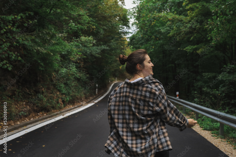 beautiful girl walks in the forest near the road beautiful girl walks in the forest near the road