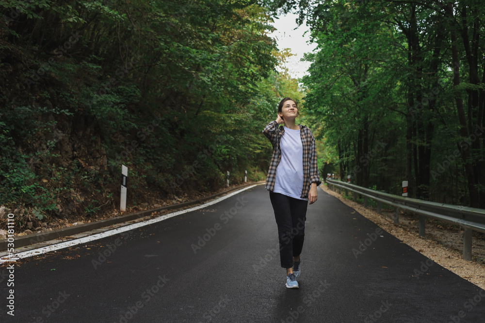 beautiful girl walks in the forest near the road beautiful girl walks in the forest near the road