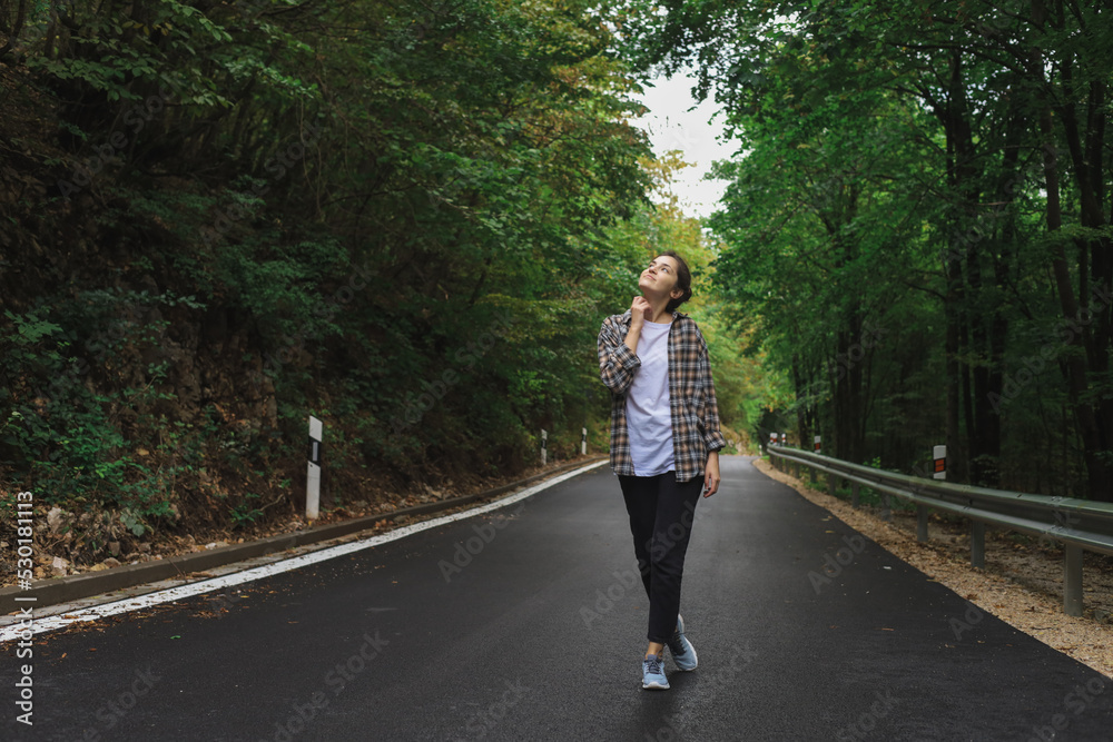 beautiful girl walks in the forest near the road beautiful girl walks in the forest near the road