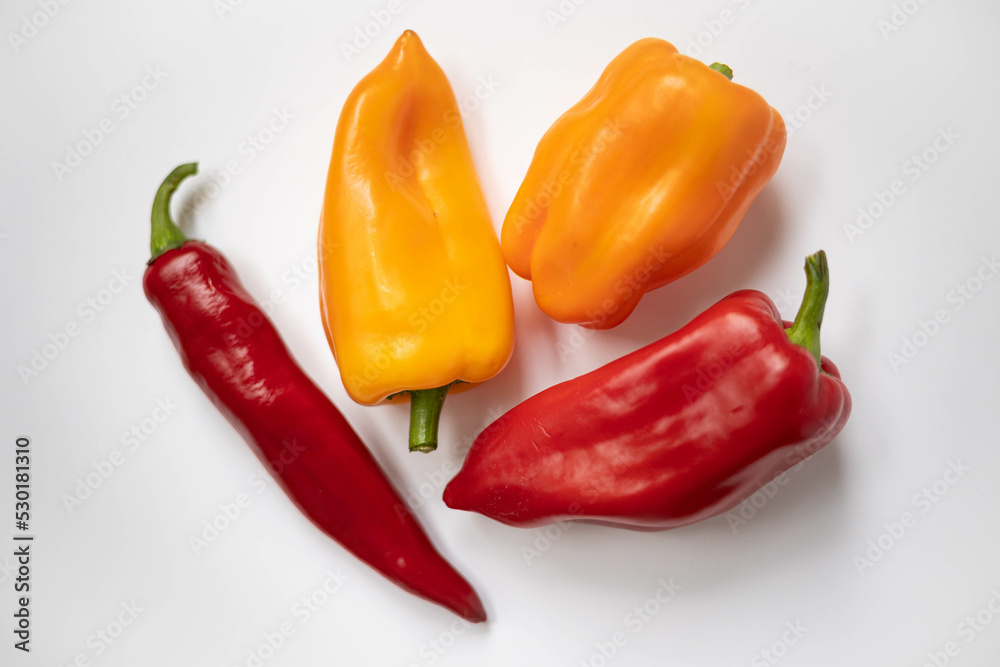 Red and yellow peppers on a white background. Red and yellow peppers on a white background.