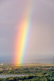 A vibrantly coloured rainbow appears over the city of Thunder Bay, Ontario as seen from Mount McKay lookout during sunset.