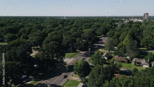 Drone flying around suburb neighborhoods with city skyscrapers in the background.