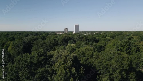 Drone flying around suburb neighborhoods with city skyscrapers in the background.