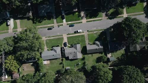 Drone flying around suburb neighborhoods with city skyscrapers in the background.