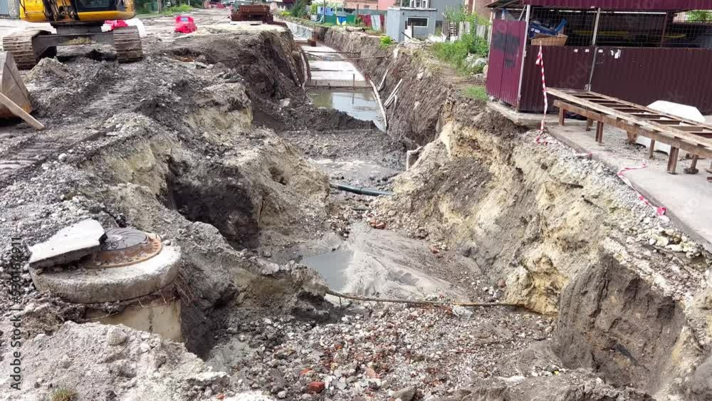 A trench dug in the ground by an excavator for laying gas and sewage ...