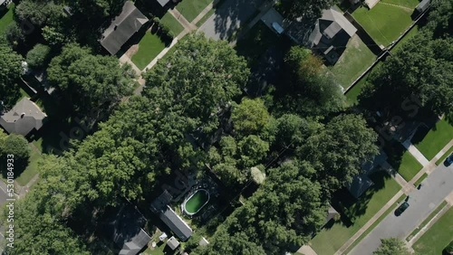 Drone flying around suburb neighborhoods with city skyscrapers in the background.