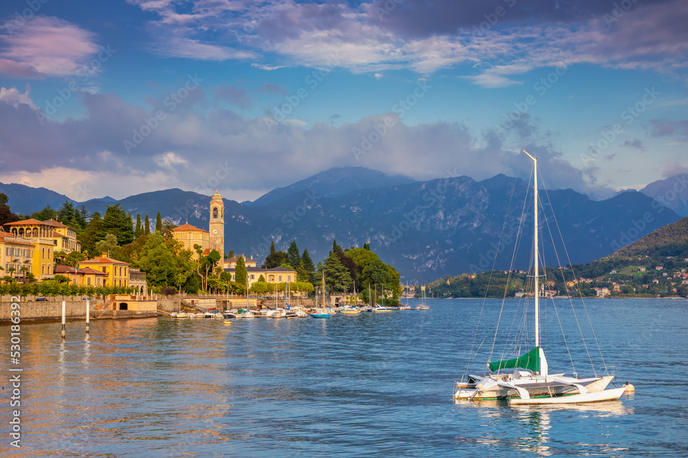 Lake Como coastline with Tremezzo village and sailboats at sunny day, Italy