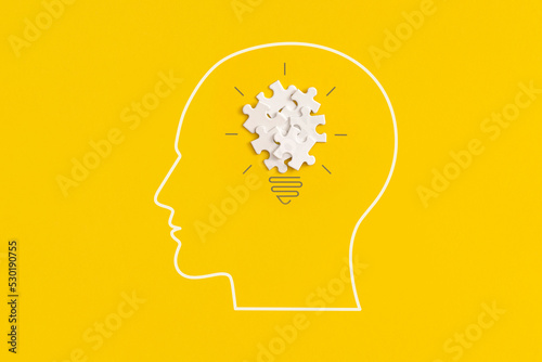 Human head with lightbulb on yellow background