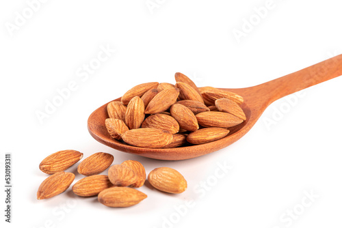 Almonds in a wooden spoon on white background.