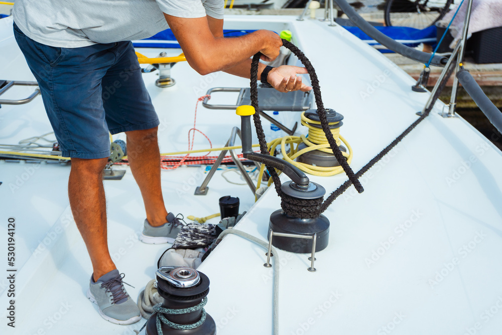 beginner courses for men on a sailing yacht. a man pulls a rope from a ...