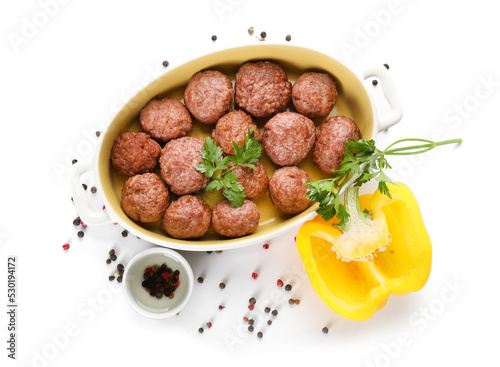 Baking dish with tasty meat balls and peppercorns on white background