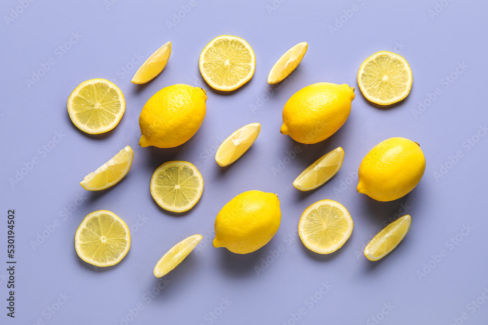 Composition with whole and cut lemons on lilac background