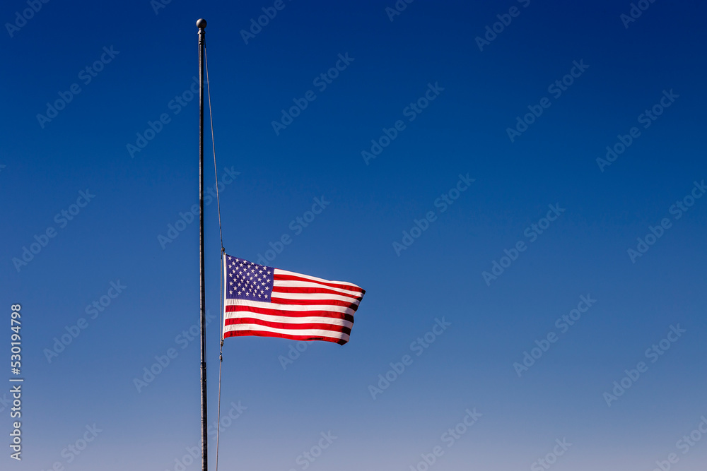 American flag blowing on blue sky at half mast in New York, september 11, USA