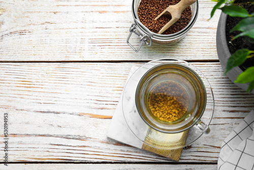 Freshly made buckwheat tea on white wooden table, flat lay. Space for text photo