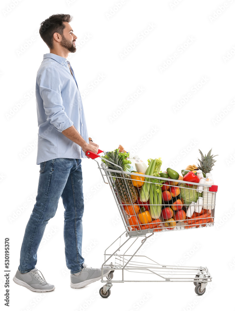 Young man with shopping cart full of groceries on white background Young man with shopping cart full of groceries on white background