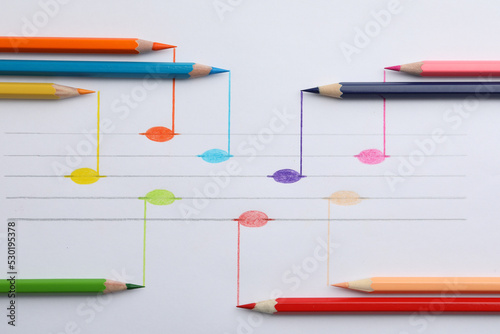 Drawing of musical notes and colorful pencils on white background, top view