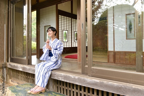 古民家の縁側に座り微笑む浴衣を着た若く綺麗な女性  © Shoji