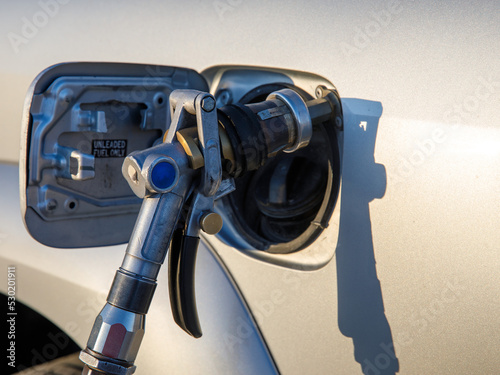 Close-up detail view of fuel autogas pump gun connected with noozle adapter to car tank to refill at car gas filling station. Refueling vehicle with liquefied lpg or lng product. Safety technology