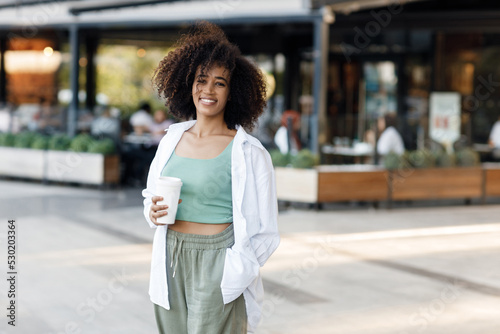 pretty young afro woman with coffee outdoors © GTeam
