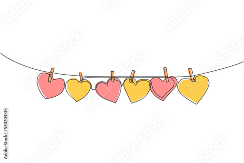 One continuous line drawing of cute heart shape paper hanged on the rope with clothesline. Romantic marriage greeting card concept. Trendy single line draw design graphic vector illustration