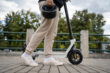 unknown man standing or driving electric kick scooter e-scooter