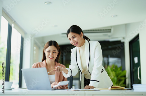 beautiful female employees discussing while working on a computer