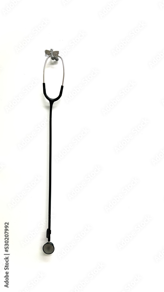 A black stethoscope hanging on the white wall background for help treatment of sick patients. A black stethoscope hanging on the white wall background for help treatment of sick patients.