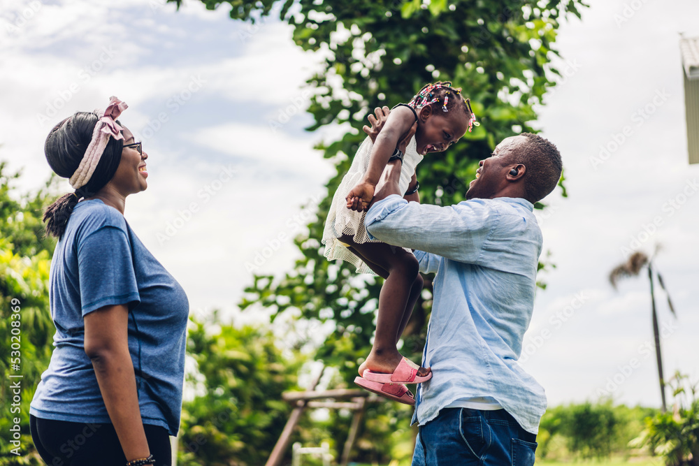 Portrait of enjoy happy love black family african american father and mother with little african girl child smiling and play having fun moments good time in room at home