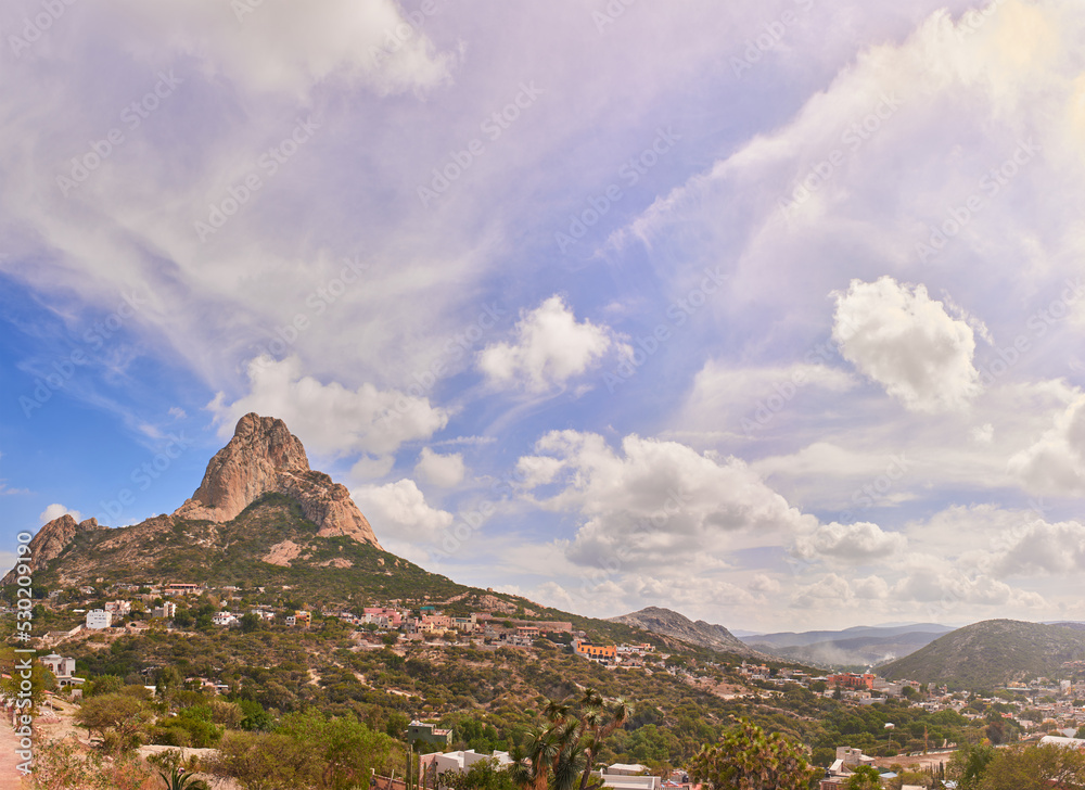 Beautiful panorama of the Peña del Bernal in a sunny morning with clouds and blue sky