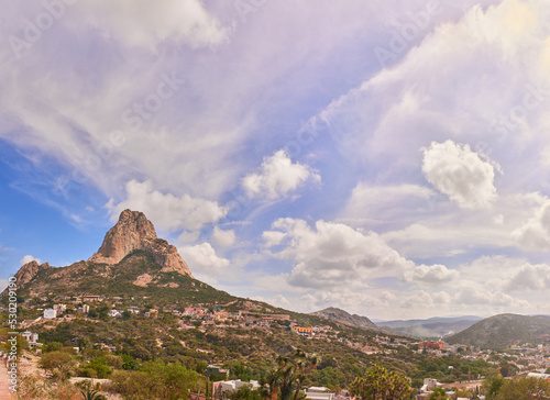 Beautiful panorama of the Peña del Bernal in a sunny morning with clouds and blue sky photo