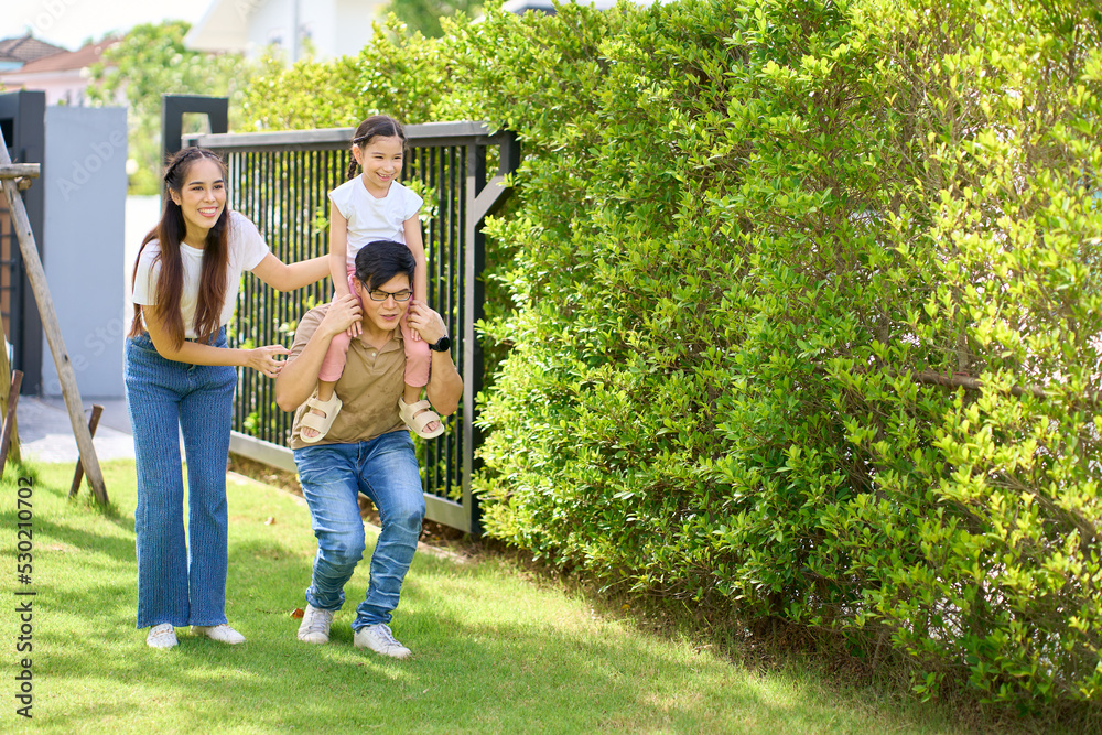 Obraz premium Happy Asian Family enjoying family time together in the home garden