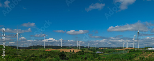 Countryside landscape of hills and turbines field with blue sky cloud background. Windmill Power Farm.